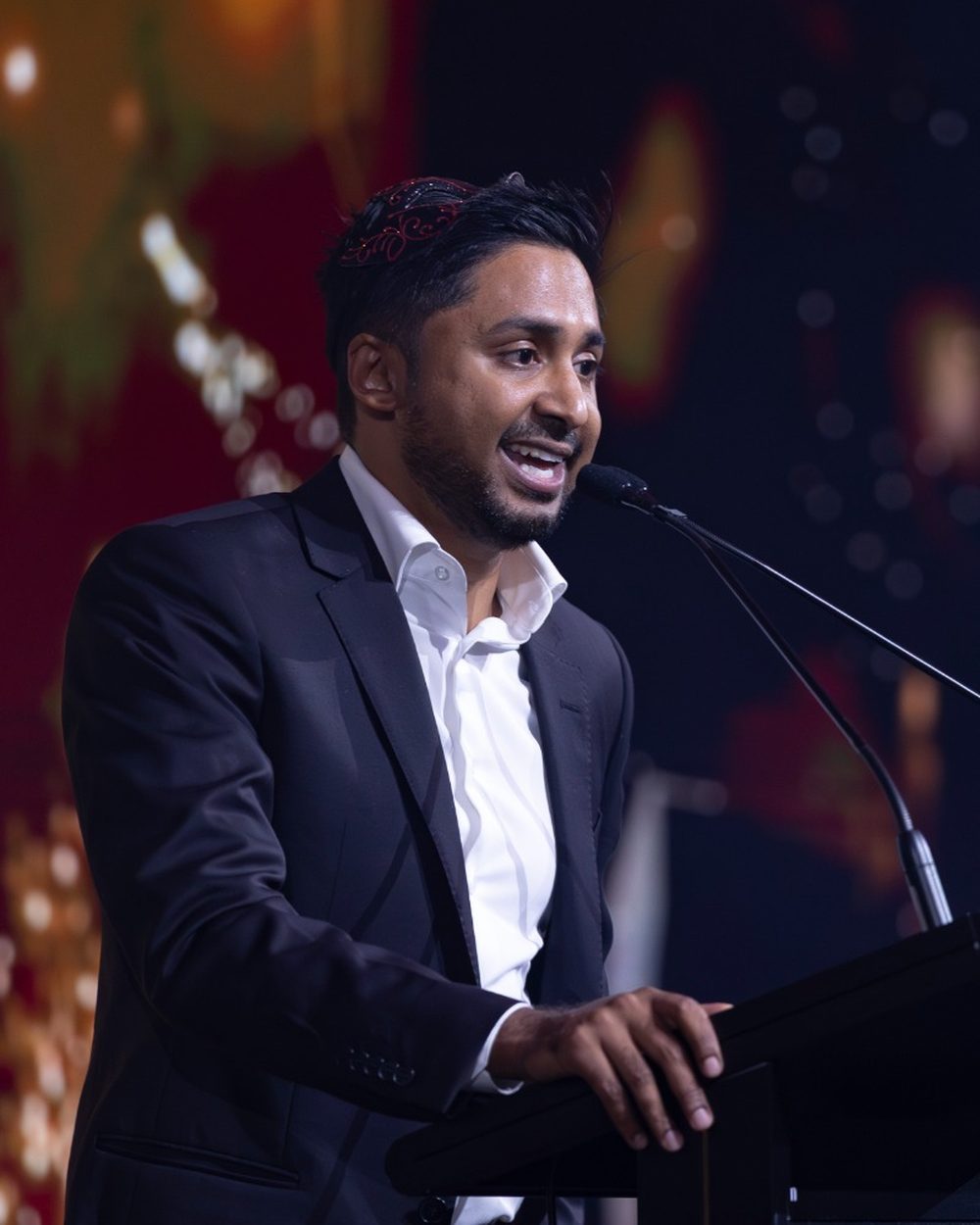 Redom Syed speaking at a podium